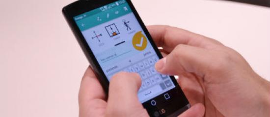 Interfaz de la aplicación en la pantalla de un móvil que sujetan dos manos.